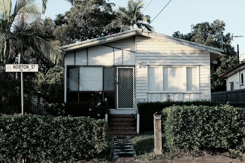 A small weatherboard house among trees