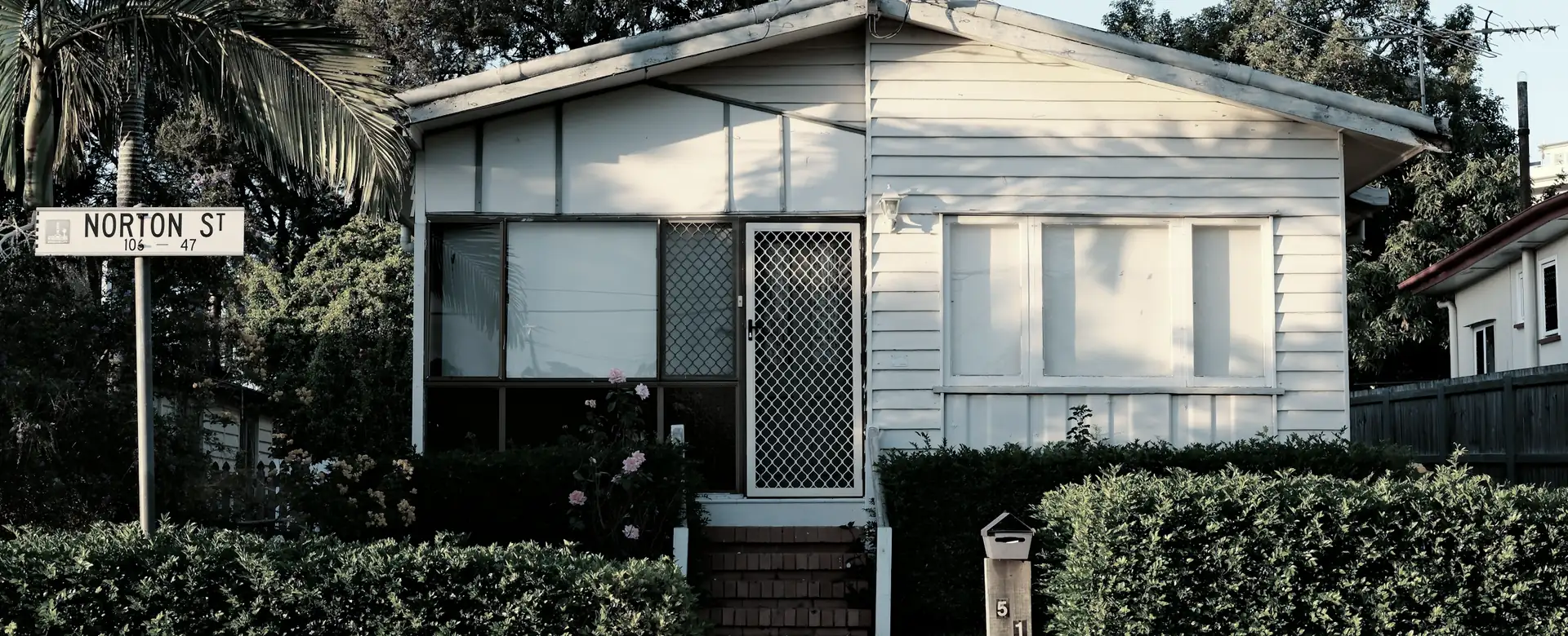 A small weatherboard house among trees