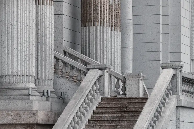 Stone steps rising between classical columns