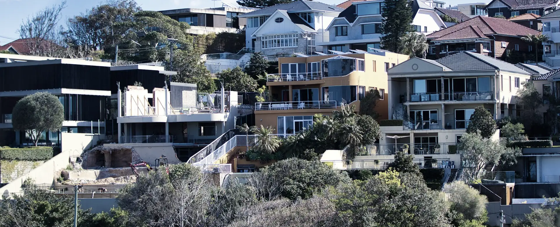 Modern houses stepping up a green hillside