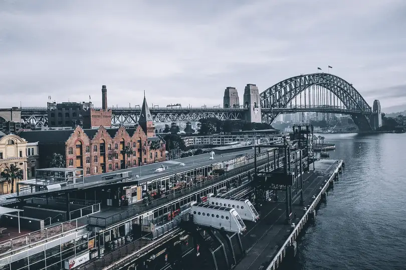 City buildings, wharves and a bridge beside the water, seen from the air