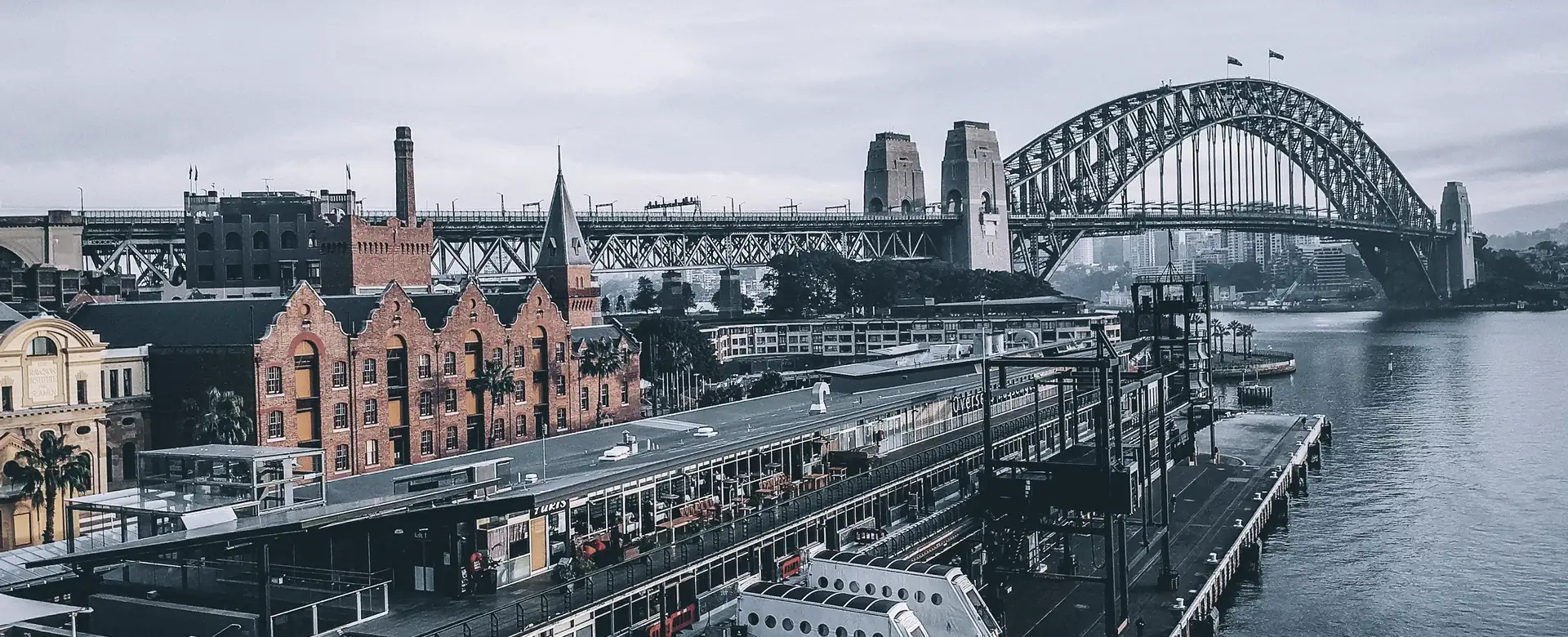 City buildings, wharves and a bridge beside the water, seen from the air