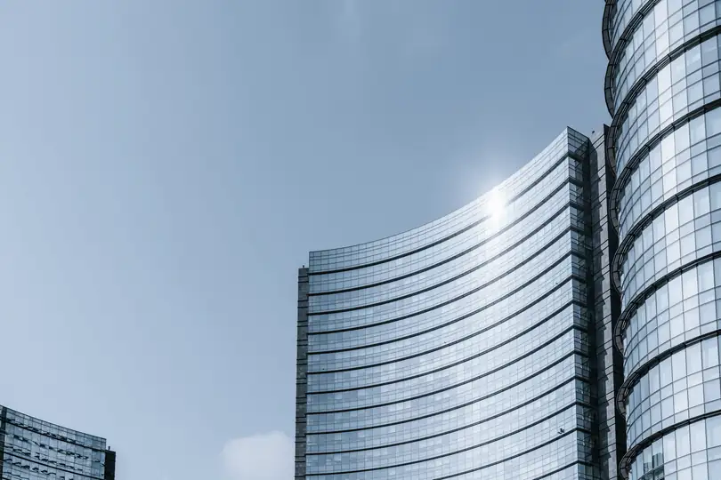 Two glass office towers in sunlight