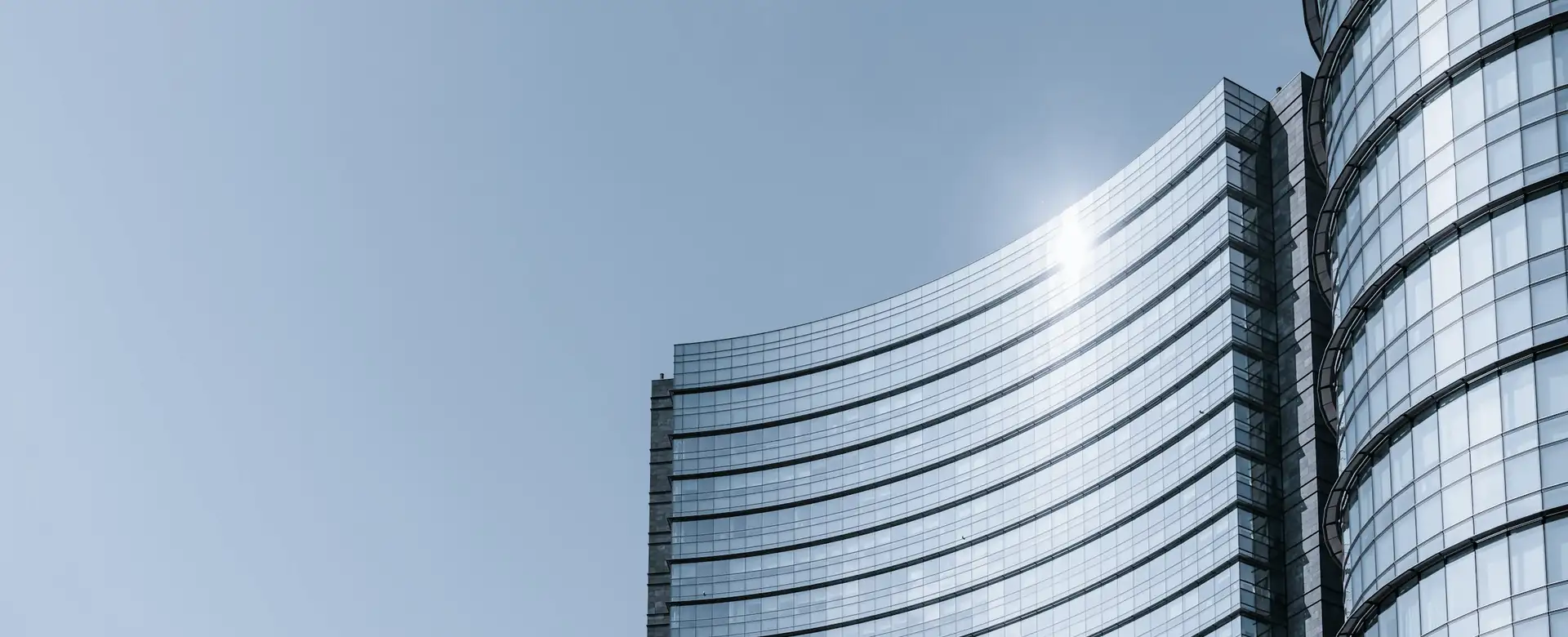 Two glass office towers in sunlight