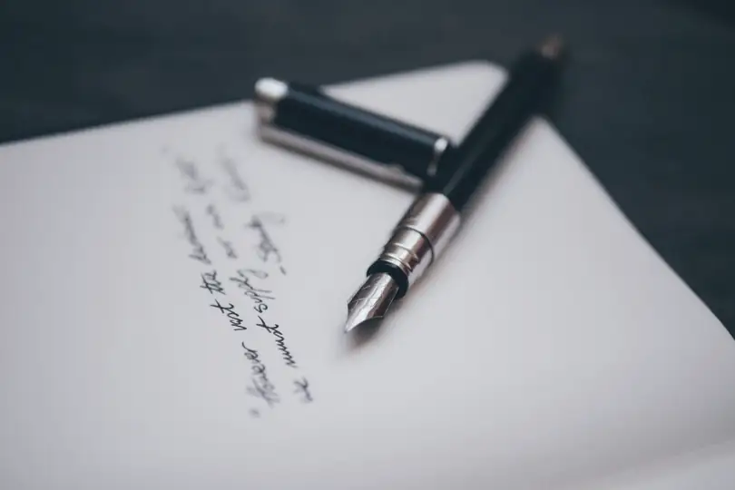 A fountain pen lying on a handwritten page