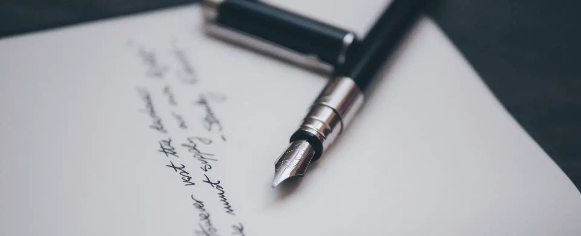 A fountain pen lying on a handwritten page