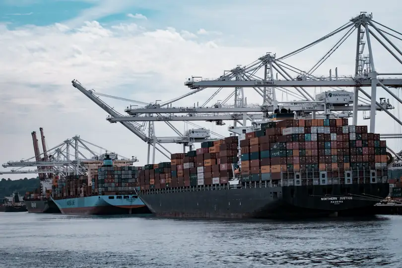 A container ship loading under cranes at a port