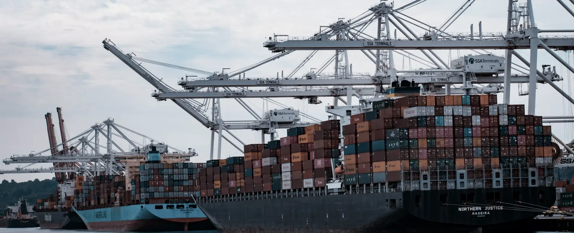 A container ship loading under cranes at a port