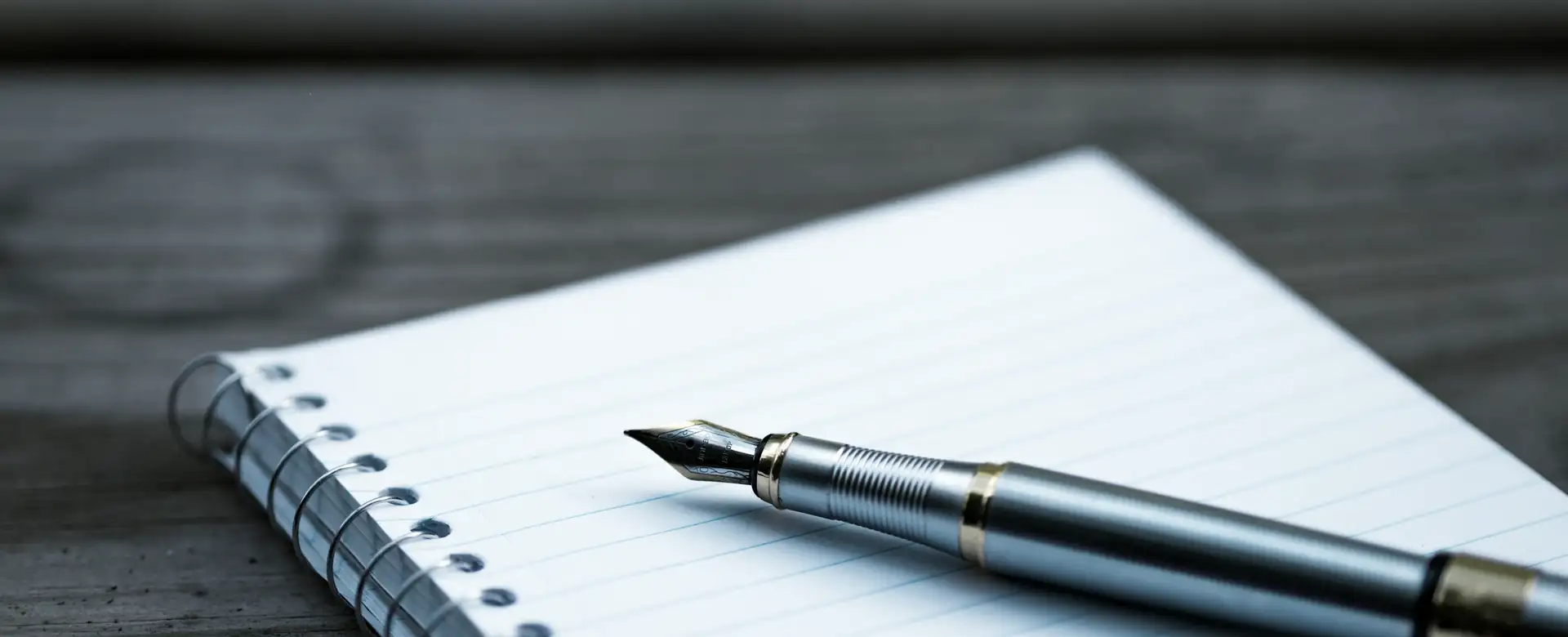 A fountain pen resting on an open notebook