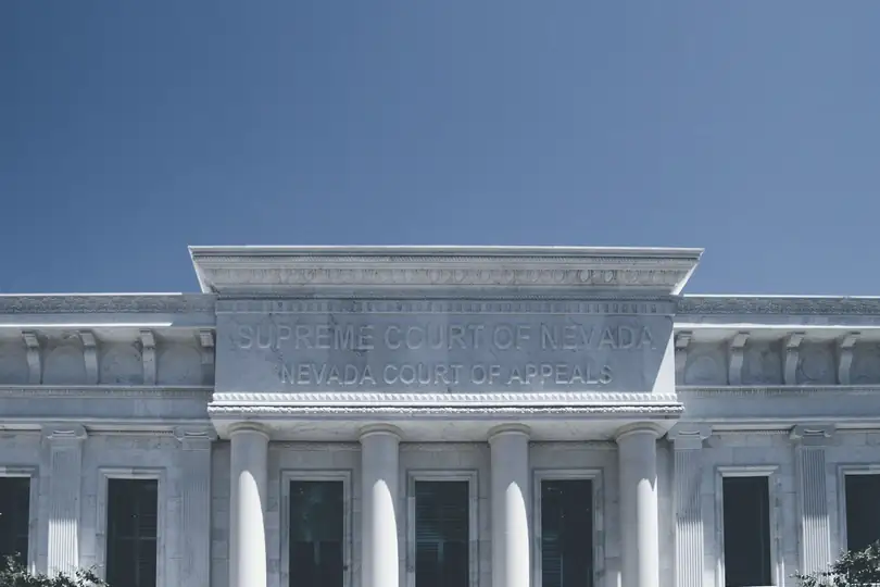 The top of a white classical building against a blue sky