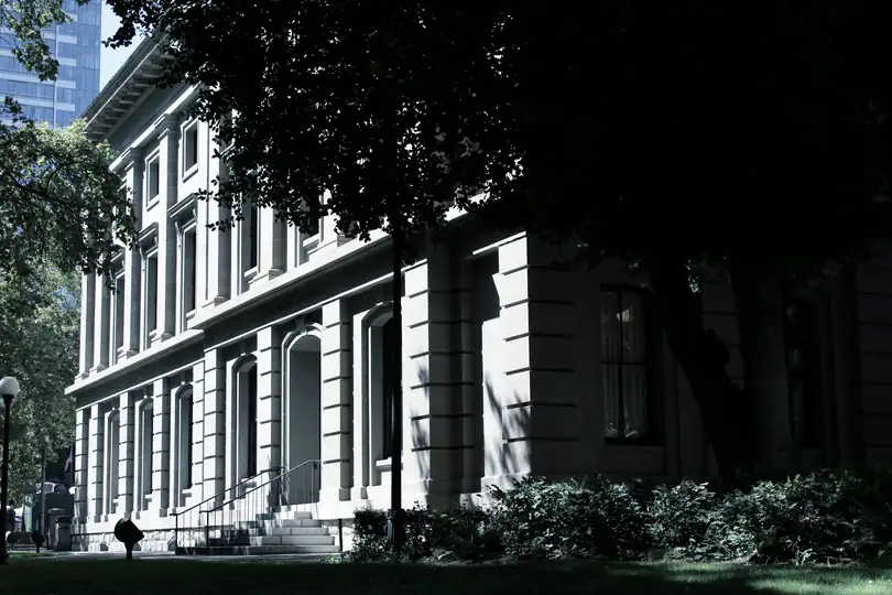 A stone civic building among trees