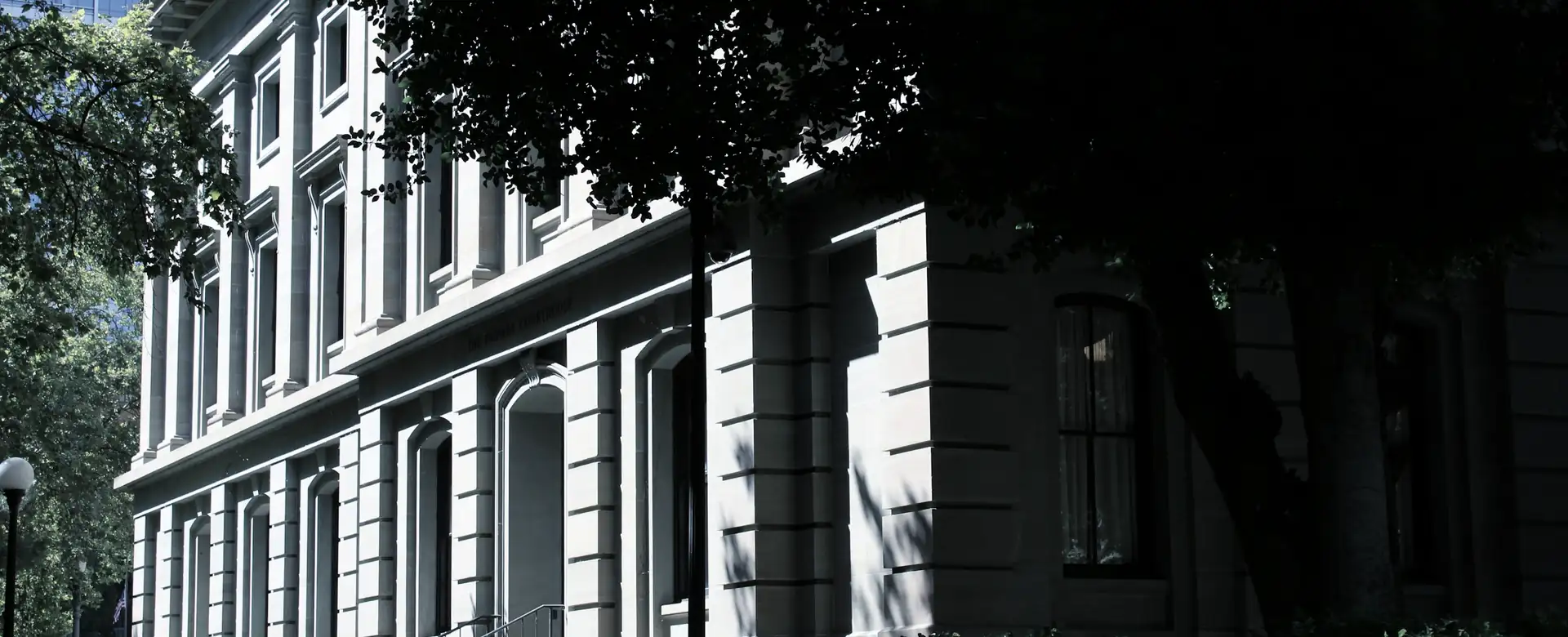 A stone civic building among trees