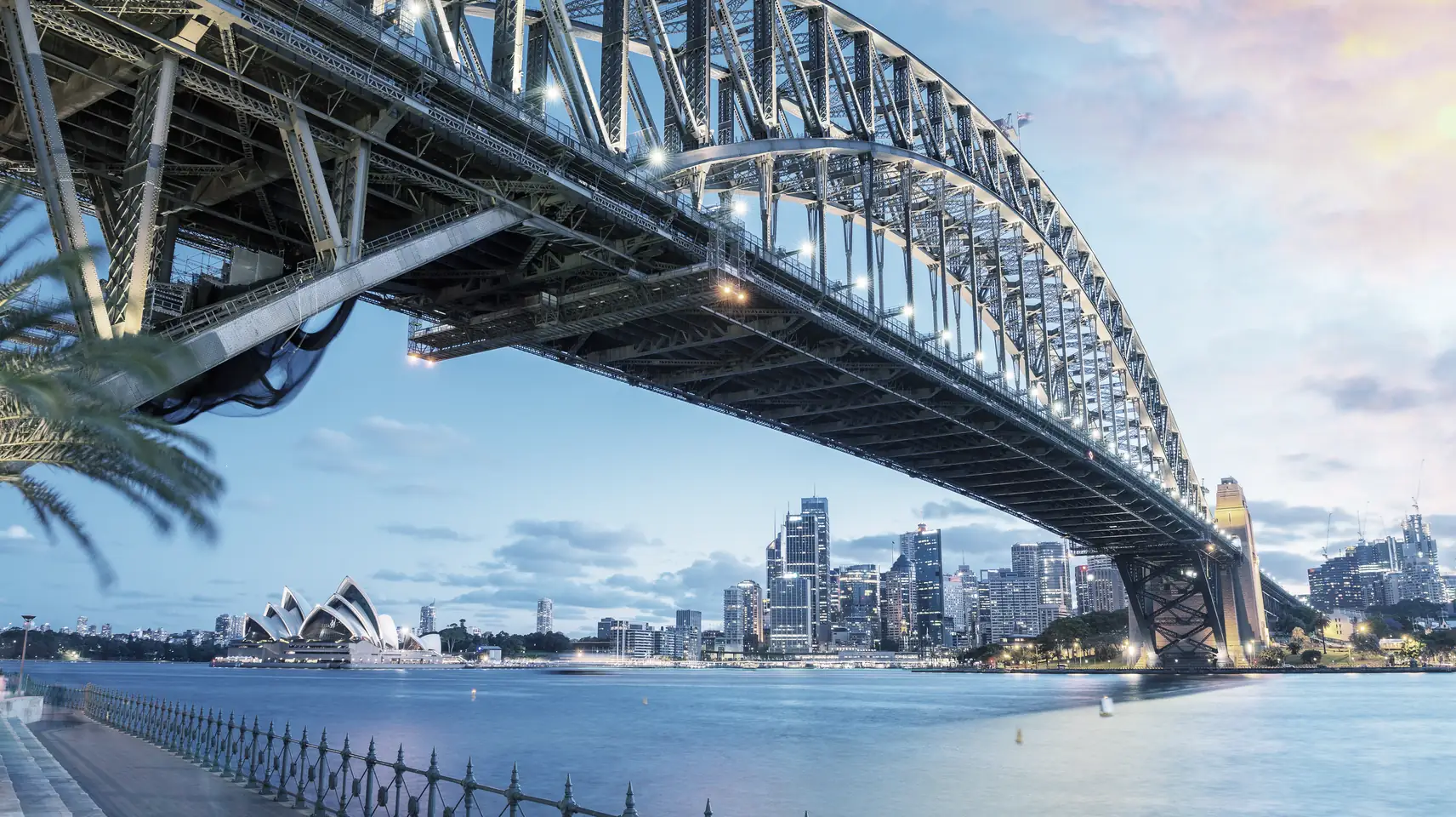 Sydney Harbour Bridge from below, with the Opera House and city beyond