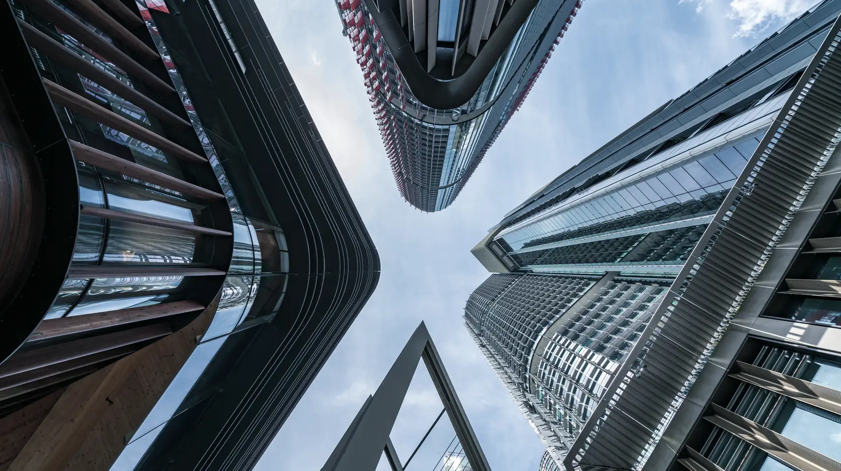 Glass office towers seen from street level, looking straight up